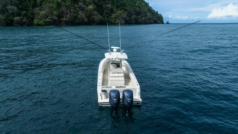 D Flawless Yacht Photos Pics 2007 Contender 33 boat with dual engines on open sea near lush island.