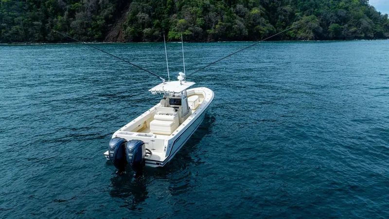 D Flawless Yacht Photos Pics 2007 Contender 33 boat with dual engines on open water near lush coastline.