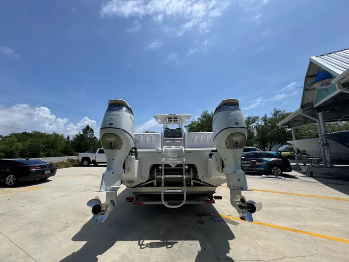  Yacht Photos Pics 2022 Twin Vee 340 GFX CC boat with dual outboard motors in a sunny parking lot.