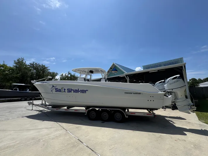  Yacht Photos Pics 2022 Twin Vee 340 GFX CC boat on trailer, labeled "Salt Shaker," under clear blue sky.