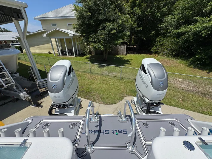  Yacht Photos Pics 2022 Twin Vee 340 GFX CC boat with dual Suzuki outboard engines, docked near a house.