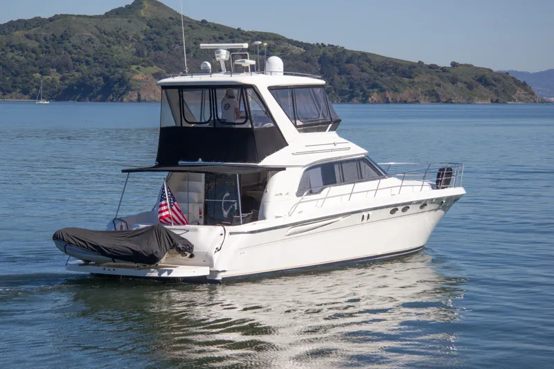 Eclipse Yacht Photos Pics 1998 Sea Ray 480 Sedan Bridge yacht cruising on calm waters with scenic hills in background.