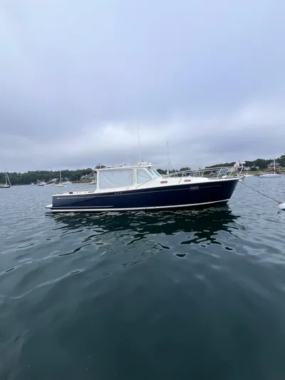 Barbican V Yacht Photos Pics 2014 MJM 36z Downeast boat on calm water, overcast sky.