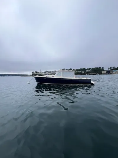 Barbican V Yacht Photos Pics 2014 MJM 36z Downeast boat on calm water, overcast sky.