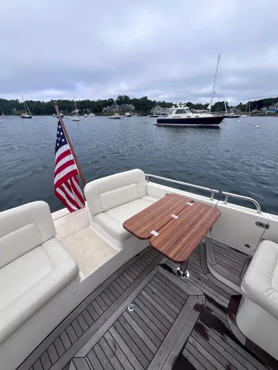 Barbican V Yacht Photos Pics 2014 MJM 36z Downeast boat with American flag, wooden deck, and scenic harbor view.