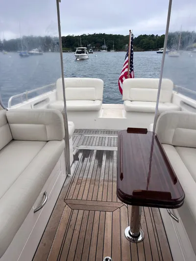 Barbican V Yacht Photos Pics 2014 MJM 36z Downeast boat interior with seating and wooden table, docked on a calm lake.