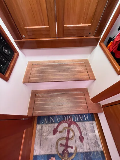 Barbican V Yacht Photos Pics Wooden steps inside a 2014 MJM 36z Downeast boat with nautical-themed rug.
