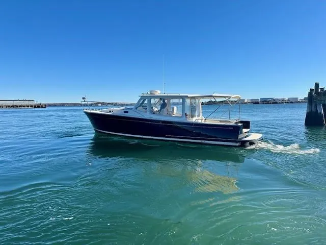 Barbican V Yacht Photos Pics 2014 MJM 36z Downeast boat cruising on clear blue water.