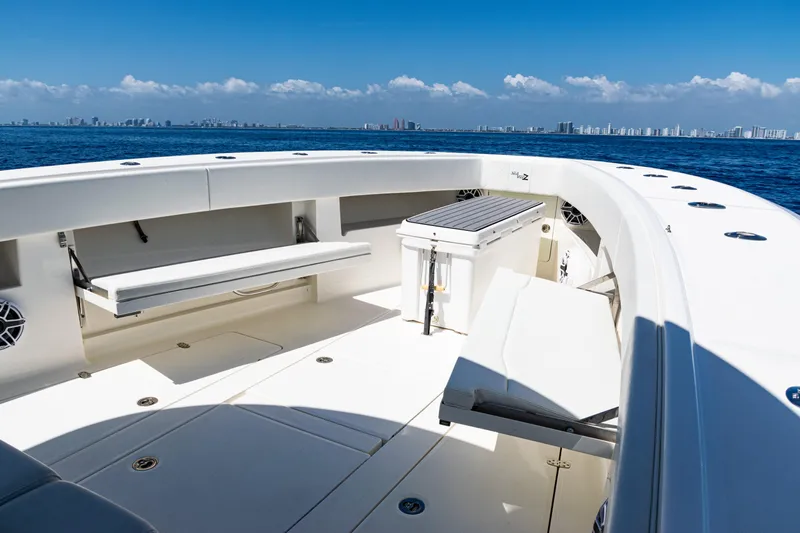  Yacht Photos Pics 2019 SeaVee 390Z boat deck with seating, ocean view, and city skyline in the background.