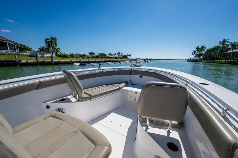  Yacht Photos Pics 2023 Sportsman Open 302 Center Console boat interior with seating, on a sunny waterway.