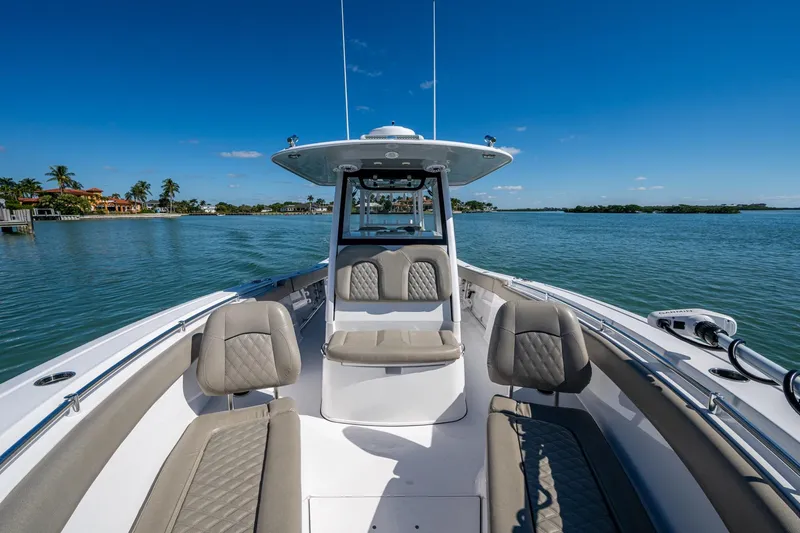  Yacht Photos Pics 2023 Sportsman Open 302 Center Console boat on calm water, featuring luxurious seating.