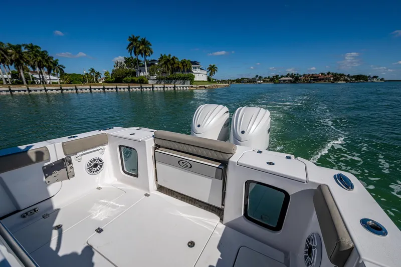  Yacht Photos Pics 2023 Sportsman Open 302 Center Console boat cruising on a sunny day, featuring dual engines.