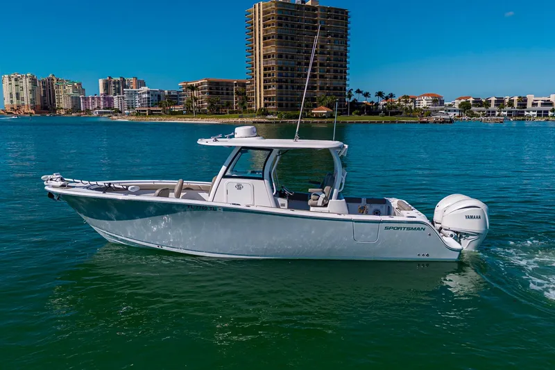  Yacht Photos Pics 2023 Sportsman Open 302 Center Console boat cruising on a sunny waterfront.