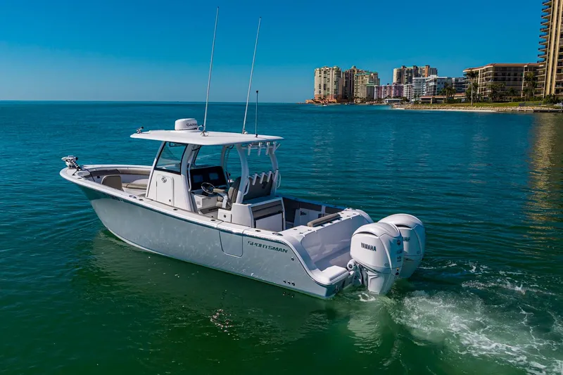  Yacht Photos Pics 2023 Sportsman Open 302 Center Console boat cruising near coastal city skyline.