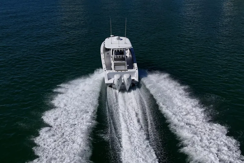  Yacht Photos Pics 2023 Sportsman Open 302 Center Console cruising on open water, rear view.