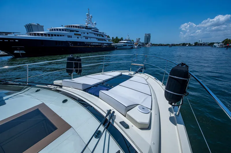 Blue B Yacht Photos Pics 2015 Beneteau MONTE CARLO yacht with sunbathing deck, docked near luxury vessels.