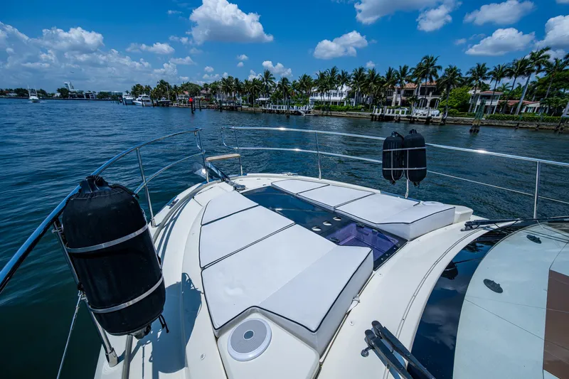 Blue B Yacht Photos Pics 2015 Beneteau Monte Carlo yacht with sunbathing deck, cruising on a scenic waterway.