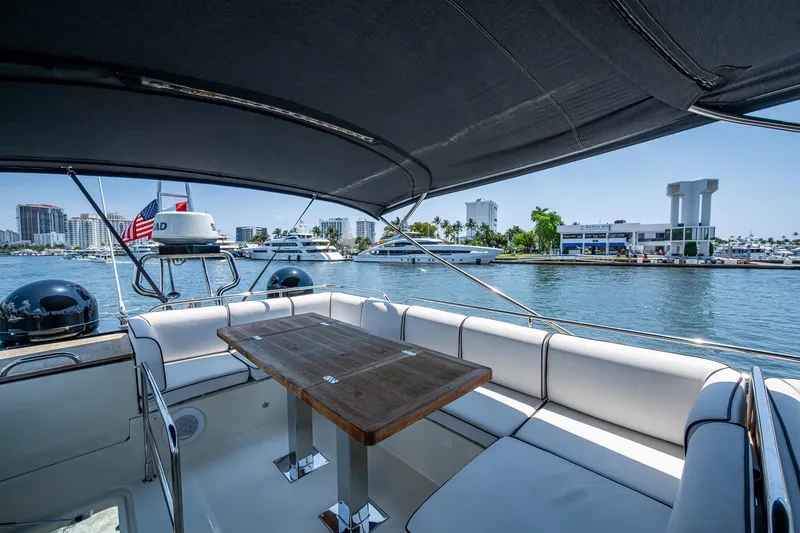 Blue B Yacht Photos Pics 2015 Beneteau Monte Carlo yacht with shaded seating area and waterfront view.
