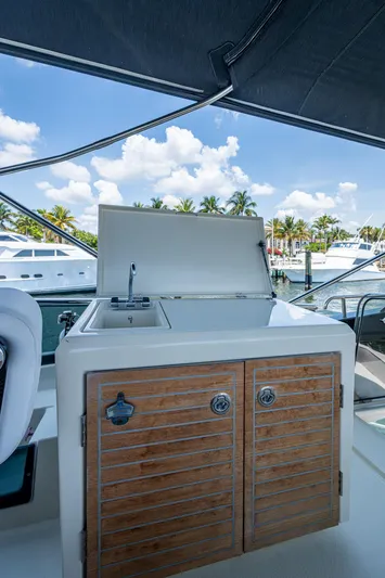 Blue B Yacht Photos Pics 2015 Beneteau Monte Carlo yacht with outdoor kitchenette, docked under a clear blue sky.