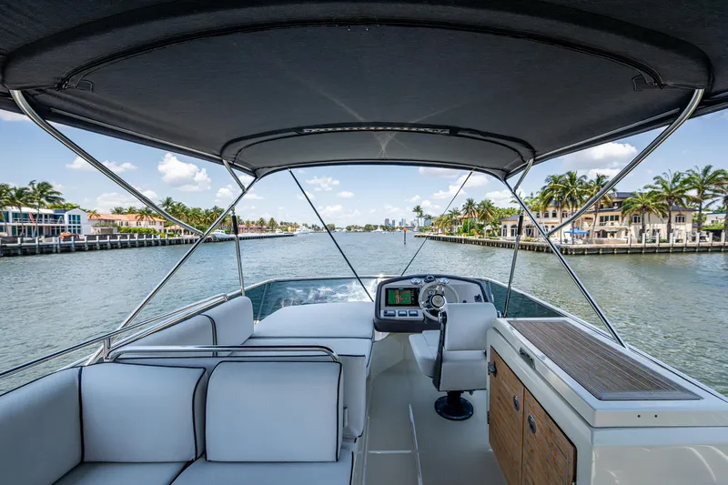 Blue B Yacht Photos Pics 2015 Beneteau MONTE CARLO yacht interior with helm, white seating, and waterfront view.