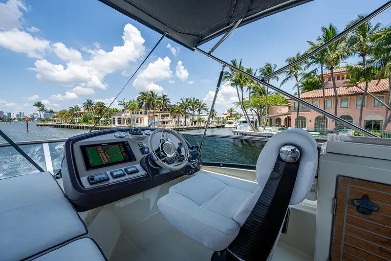 Blue B Yacht Photos Pics Helm of 2015 Beneteau Monte Carlo yacht with waterfront view and palm trees.