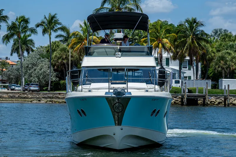 Blue B Yacht Photos Pics 2015 Beneteau MONTE CARLO yacht cruising on a sunny day with palm trees in the background.