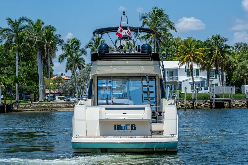 Blue B Yacht Photos Pics 2015 Beneteau MONTE CARLO yacht cruising near palm-lined waterfront homes.