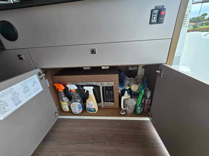  Yacht Photos Pics Cupboard storage in 2020 Beneteau Antares 9 OB with cleaning supplies and microwave.