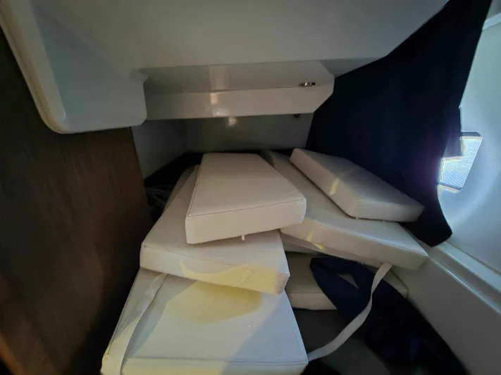  Yacht Photos Pics Interior cabin of 2020 Beneteau Antares 9 OB with stacked white cushions.
