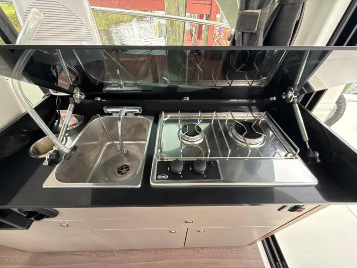  Yacht Photos Pics Compact kitchen area in a 2020 Beneteau Antares 9 OB boat with sink and stove.