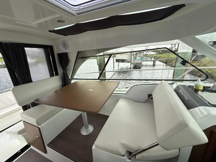  Yacht Photos Pics Interior of 2020 Beneteau Antares 9 OB, featuring a dining area with a wooden table.