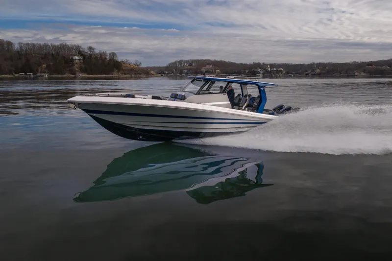  Yacht Photos Pics 2025 Fountain 43 SCX speedboat cruising on a calm lake under a cloudy sky.