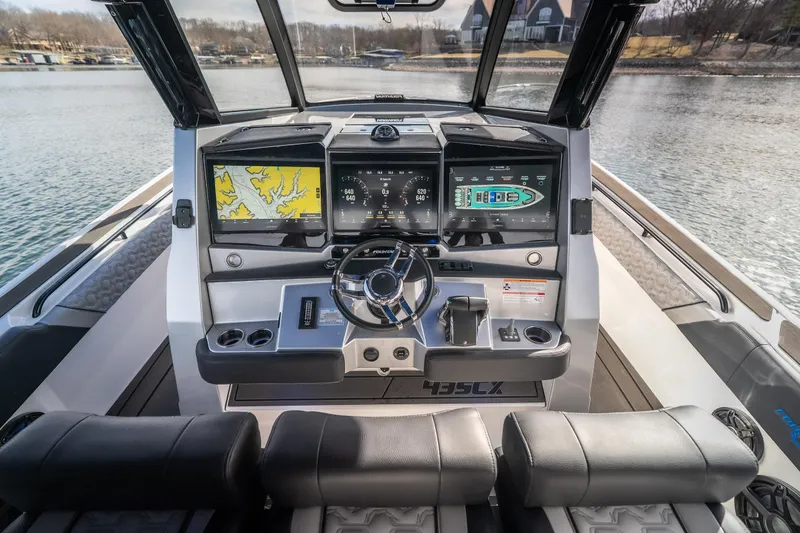  Yacht Photos Pics 2025 Fountain 43 SCX boat dashboard with navigation screens and steering wheel on a lake.