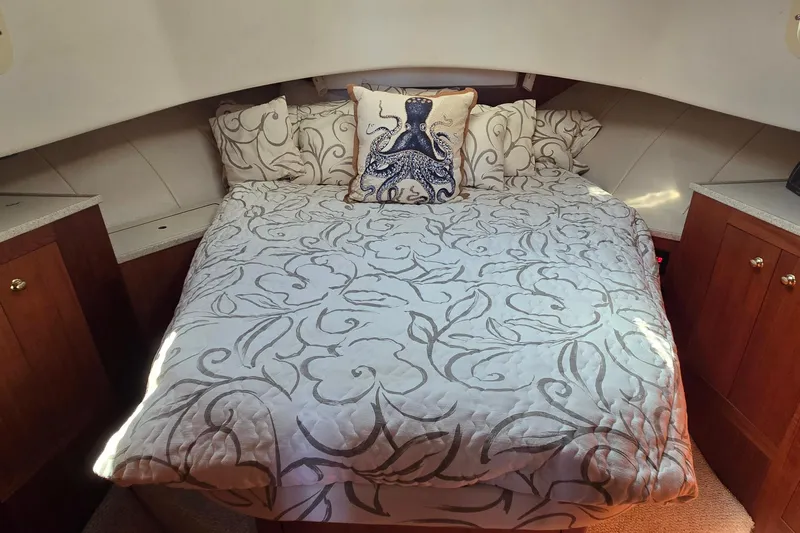 Polly Yacht Photos Pics Cozy bedroom in 2000 Mainship 390 Trawler with nautical-themed decor and elegant bedding.