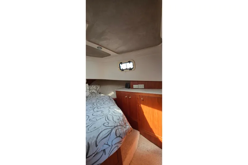 Polly Yacht Photos Pics Cozy cabin interior of 2000 Mainship 390 Trawler with bed and wooden cabinetry.