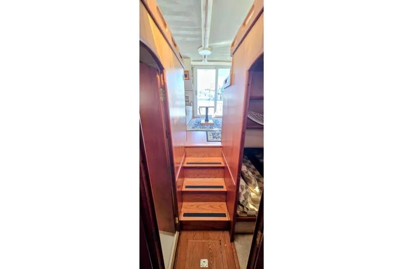 Polly Yacht Photos Pics Interior view of 2000 Mainship 390 Trawler, featuring wooden stairs and cozy cabin space.