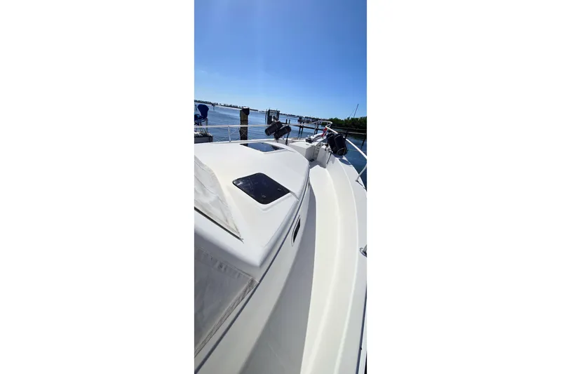 Polly Yacht Photos Pics 2000 Mainship 390 Trawler on calm water under clear blue sky.