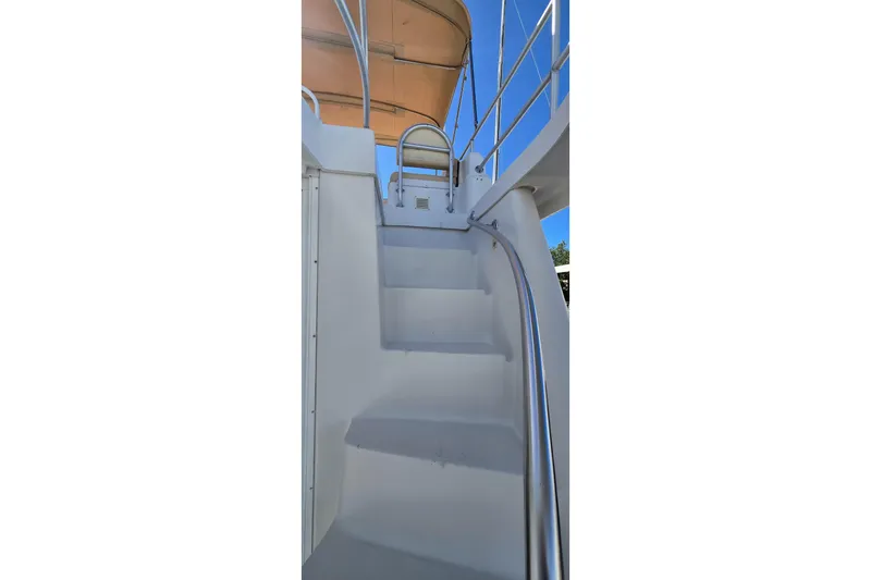 Polly Yacht Photos Pics Staircase on 2000 Mainship 390 Trawler with metal handrails and canopy.