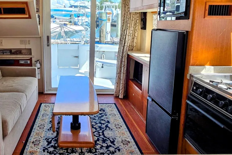 Polly Yacht Photos Pics Interior of 2000 Mainship 390 Trawler with cozy seating, kitchen, and marina view.