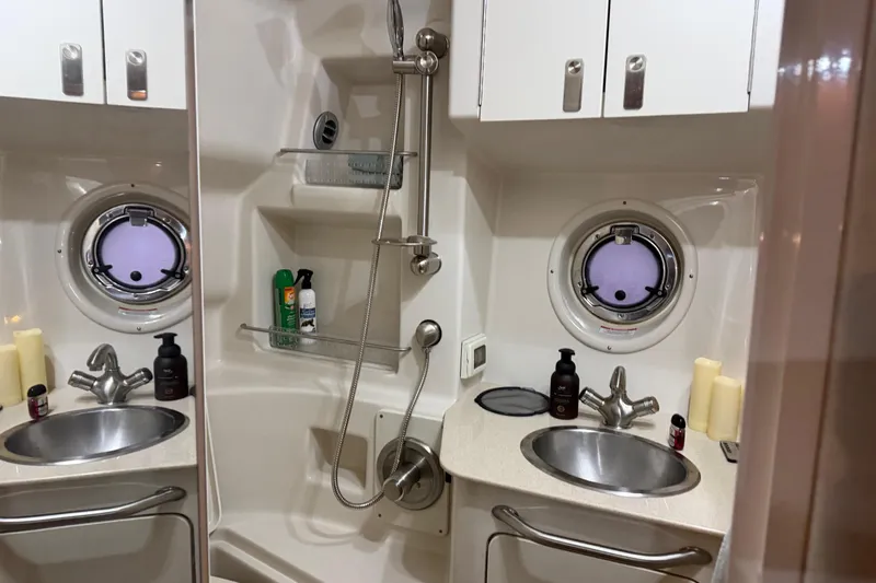 Finding Time Yacht Photos Pics 2011 Sea Ray 350 Sundancer bathroom with dual sinks, shower, and porthole windows.