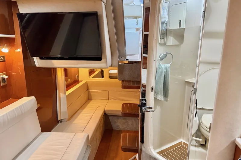 Finding Time Yacht Photos Pics Interior of 2011 Sea Ray 350 Sundancer with seating, TV, and bathroom.