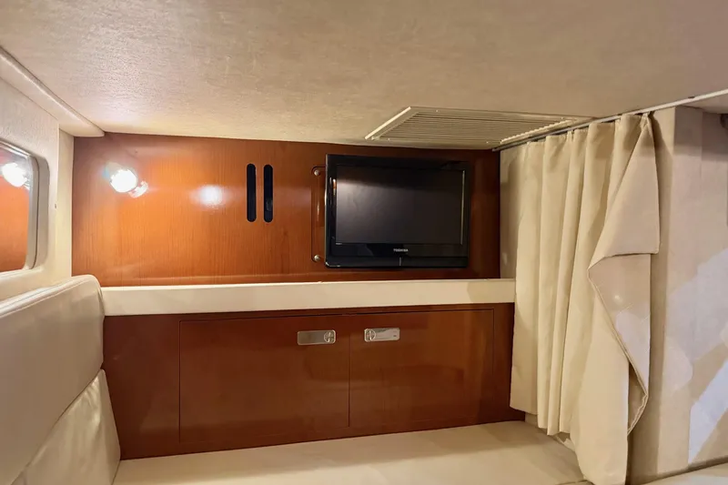 Finding Time Yacht Photos Pics 2011 Sea Ray 350 Sundancer cabin interior with TV and wooden cabinetry.