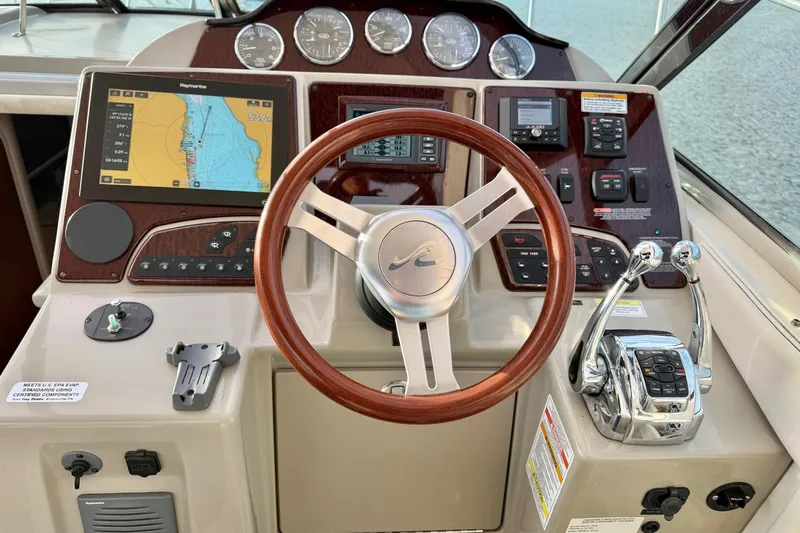 Finding Time Yacht Photos Pics Cockpit of 2011 Sea Ray 350 Sundancer with navigation system and wooden steering wheel.