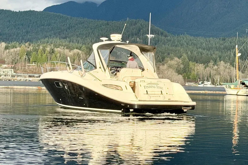 Finding Time Yacht Photos Pics 2011 Sea Ray 350 Sundancer yacht cruising on a serene lake with forested mountains.