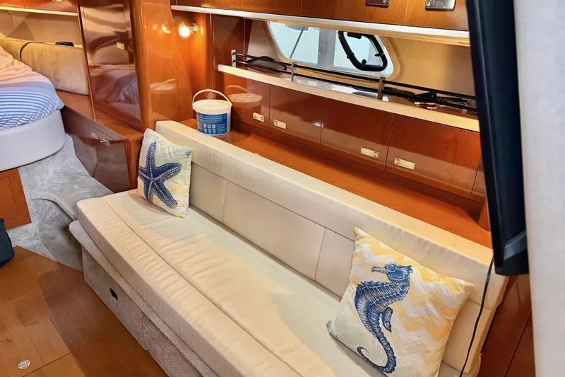 Finding Time Yacht Photos Pics Interior of 2011 Sea Ray Sundancer 350 with cozy seating and nautical-themed pillows.