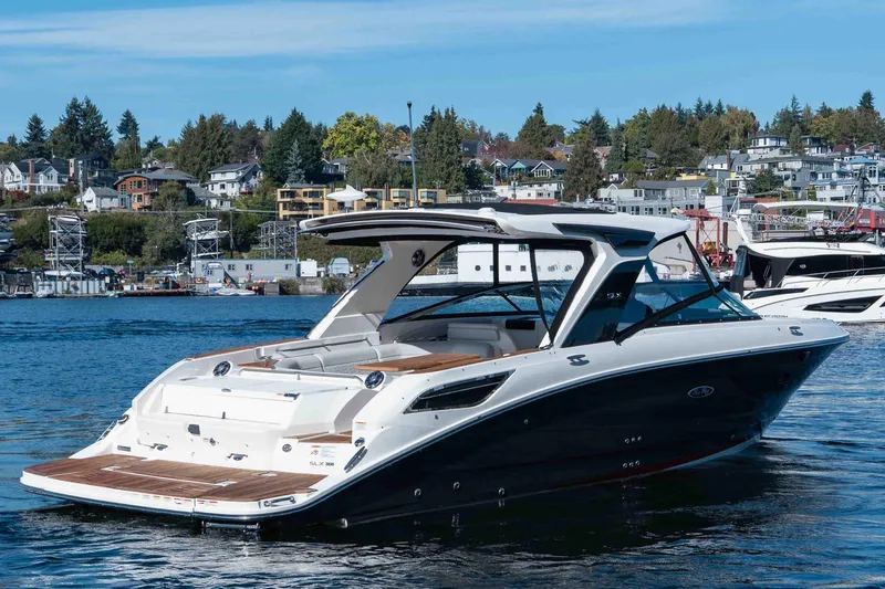  Yacht Photos Pics 2021 Sea Ray SLX 350 luxury boat on a scenic waterfront with houses in the background.