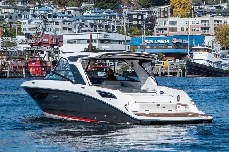  Yacht Photos Pics 2021 Sea Ray SLX 350 boat cruising in a bustling harbor with urban backdrop.