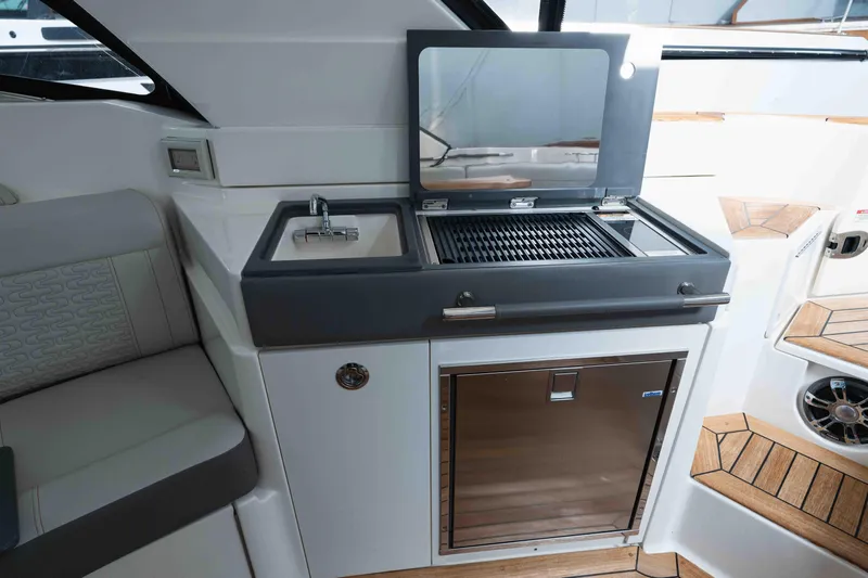  Yacht Photos Pics 2021 Sea Ray SLX 350 boat interior with grill, sink, and seating area.