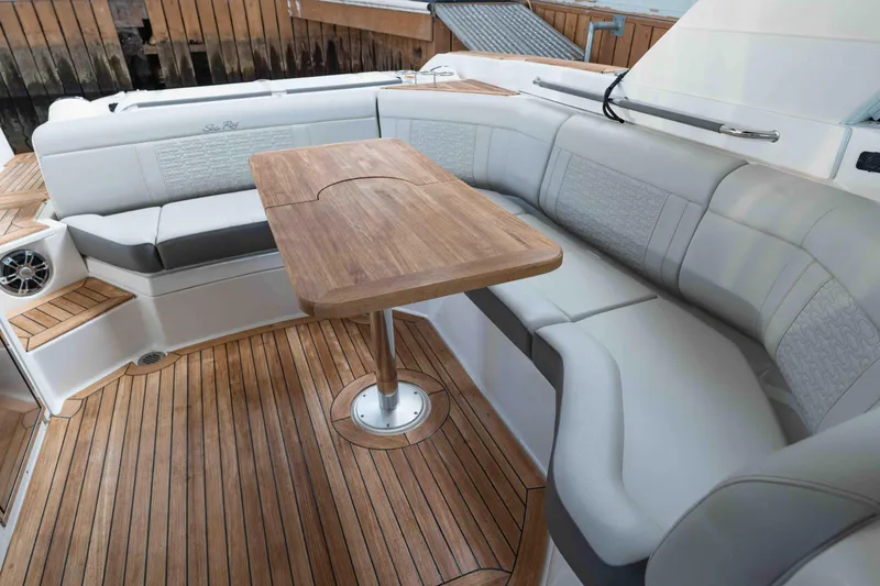  Yacht Photos Pics Luxurious seating area on 2021 Sea Ray SLX 350 boat with wooden table and flooring.
