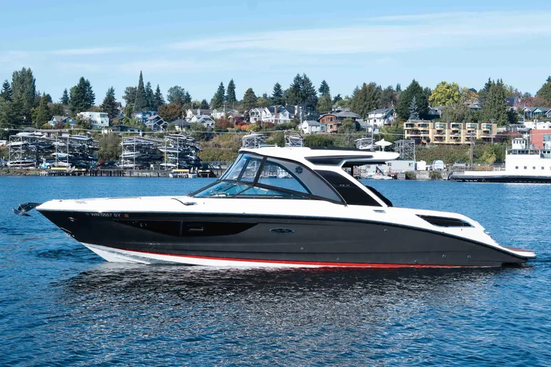  Yacht Photos Pics 2021 Sea Ray SLX 350 boat on a scenic waterfront with houses in the background.